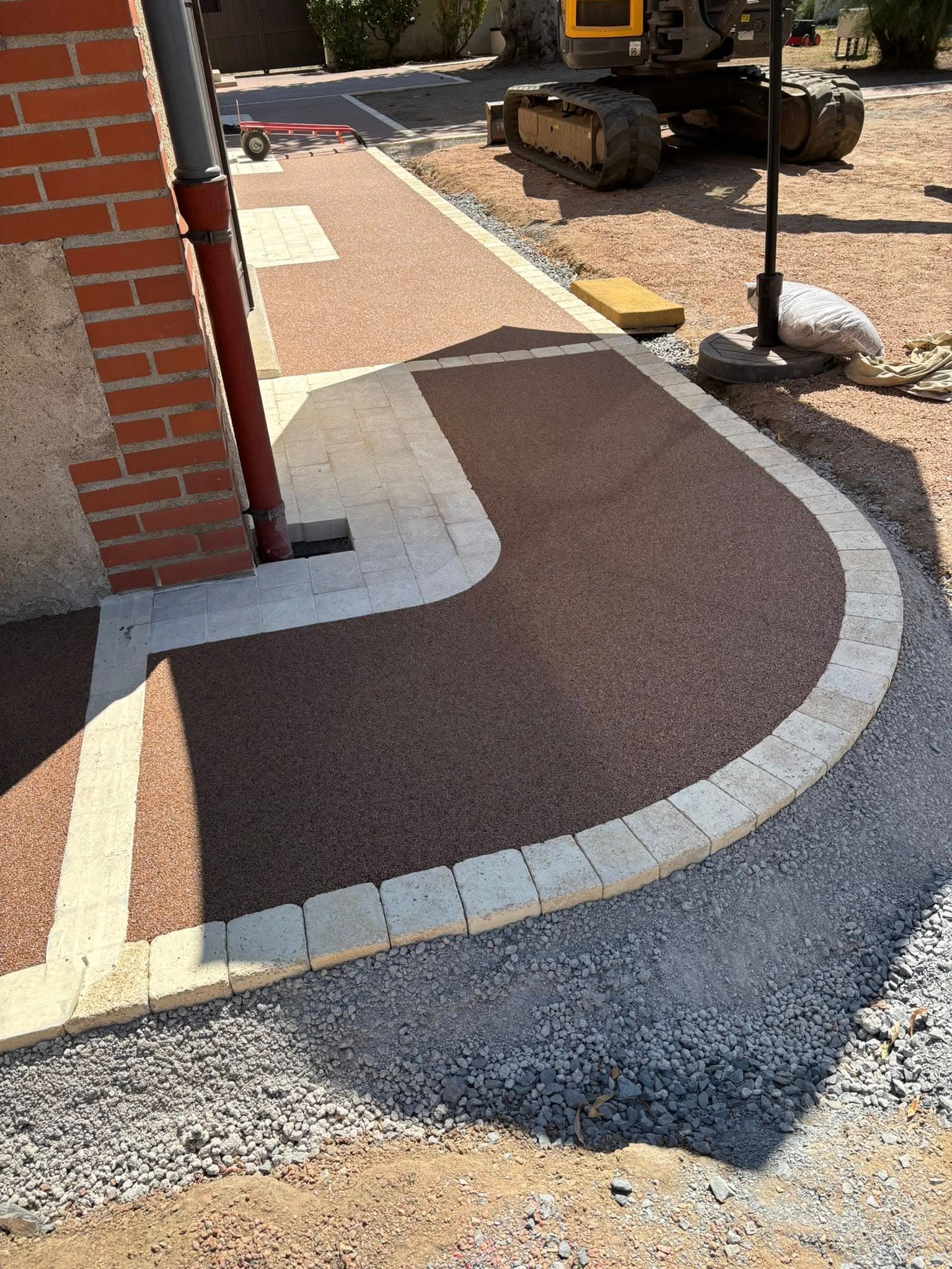 Tapis de pierre en cours de pose avec bordures pavées